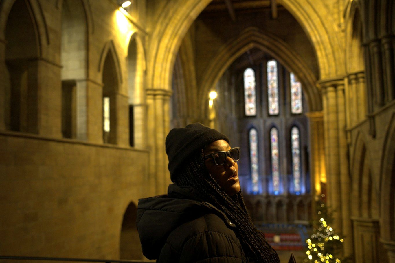 Jessica Nyassa beneath the stained glass of a cathedral choir